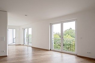 Beispielzimmer der Wohnanlage HUGO Komfort in Bayreuth mit Parkettboden und bodentiefen Fenstern