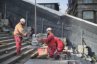 Photo of two people lifting a stair step