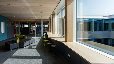 Innenaufnahme des Paul-Klee-Gymnasiums in Gersthofen. Man sieht eine Holz-Pfosten-Riegel-Fensterfassade.