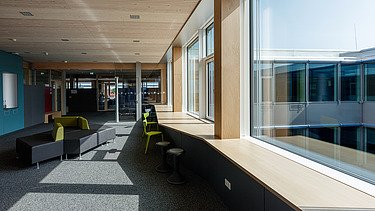 Innenaufnahme des Paul-Klee-Gymnasiums in Gersthofen. Man sieht eine Holz-Pfosten-Riegel-Fensterfassade.