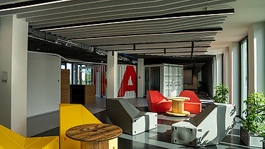 Das Innovation Center in Stuttgart, Sicht auf einen Open Space mit bunten Stühlen