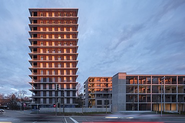 Exterior view of the CARL wooden high-rise in the evening at sunset