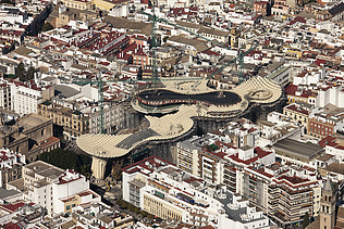 Foto einer Luftaufnahme von Sevilla. Man sieht die pilzartige Holzkonstruktion der Marktplatzüberdachung Metropol Parasol Sevilla.