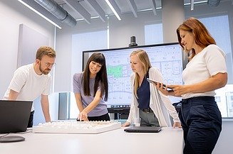 Photo of a man and three women in a meeting situation