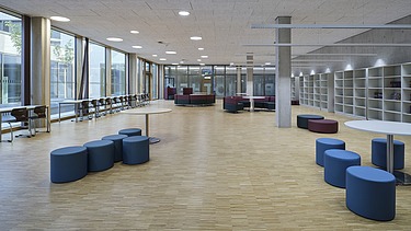 Spacious lounge with blue seating and a window front