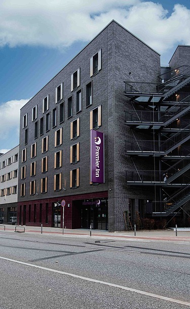 Tagesansicht des Hotelgebäudes PREMIER INN Hamburg-St. Pauli mit moderner Architektur
