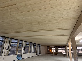 Foto des Rohbaus des Paul-Klee-Gymnasium in Gersthofen. Man sieht eine Holzdecke von unten.