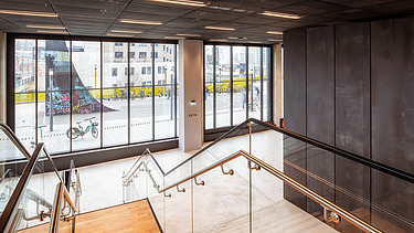 Picture looking outside, of an entrance area with stairs of an office building.