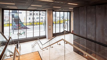 Picture looking outside, of an entrance area with stairs of an office building.