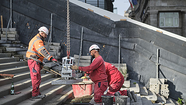 Photo of two people lifting a stair step