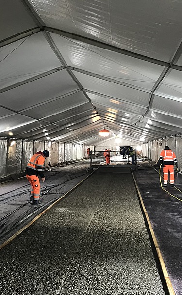 Photo of people with high-visibility vests in a tent