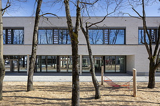 Außenaufnahme der Vinzenz-Pallotti-Schule in Friedberg. Man sieht ein großes, weißes Gebäude mit Flachdach.