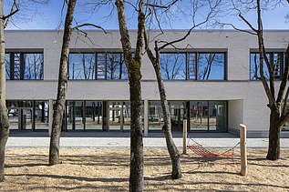 Außenaufnahme der Vinzenz-Pallotti-Schule in Friedberg. Man sieht ein großes, weißes Gebäude mit Flachdach.