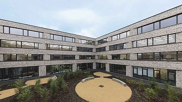 Green schoolyard with surrounding buildings