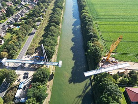 Drone shot (top view) of the Hertha-Peters Bridge construction site, a crane lifts the steel structure