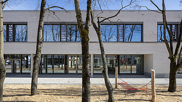 Außenaufnahme der Vinzenz-Pallotti-Schule in Friedberg. Man sieht ein großes, weißes Gebäude mit Flachdach.