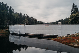 Photo of white protective tarpaulins at the dam