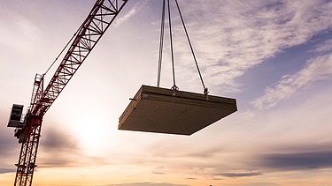 Foto des Collegium Academicums in Heidelberg während der Montage. Man sieh ein LENO-Holzelement schwebend am Kran.