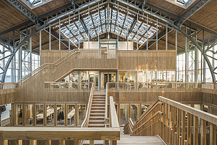 Foto des Hallenraumes des Gare Maritime Brüssel. Riesiger, offener Hallenraum mit Holzdachkonstruktion.