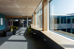 Innenaufnahme des Paul-Klee-Gymnasiums in Gersthofen. Man sieht eine Holz-Pfosten-Riegel-Fensterfassade.