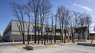 Außenaufnahme der Vinzenz-Pallotti-Schule in Friedberg. Man sieht ein großes, weißes Gebäude mit Flachdach.