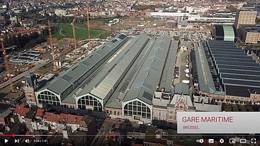 Luftaufnahme des Gare Maritime Brüssel in Norwegen. Man sieht viele Dächer von Gebäuden.