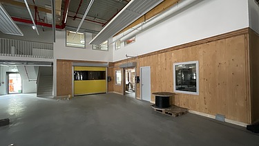 Foto des Innenausbaus einer Gewerbehalle. Man sieht LENO-Brettsperrholzwände und -decken.