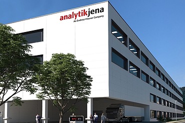 Bild zeigt ein Bürogebäude bei blauem Himmel, davor stehen zwei Bäume