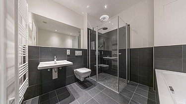 Example of a bathroom with dark tiles in the PURA residential complex