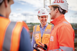 Workers on the construction site wearing ZÜBLIN helmets