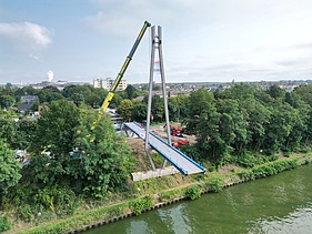 Drone shot of the Hertha Peters Bridge construction site, a crane lifts the steel structure