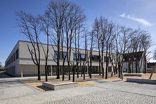 Außenaufnahme der Vinzenz-Pallotti-Schule in Friedberg. Man sieht ein großes, weißes Gebäude mit Flachdach.