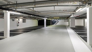 Photo of an underground parking garage with parking spaces in black color