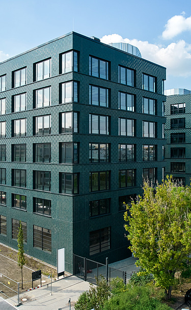 Exterior view of the INK Inspire Neukölln in Berlin with striking green façade