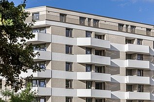 Aufnahme der Wohnanlage Atriumquartiers in Leipzig, mit hellbrauner Fassade und weißen Balkonen