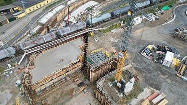 Aerial view of a construction site with railroad line and underpass