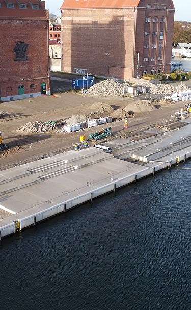 Aerial view of the construction site at Hansakai Stralsund with crane and construction elements.