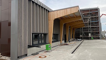 Foto der Baustelle Erbe in Rangendingen. Man sieht große Brettschichtholzträger am Eingangsbereich.