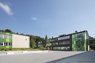 Modern architecture of the vocational school with a green façade and spacious entrance area