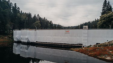 Photo of white protective tarpaulins at the dam