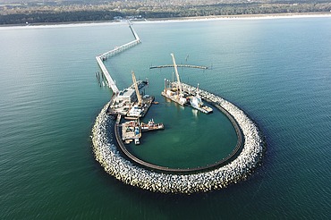 Close-up of a large crane on a construction site in the sea, part of an artificial island construction off Prerow.