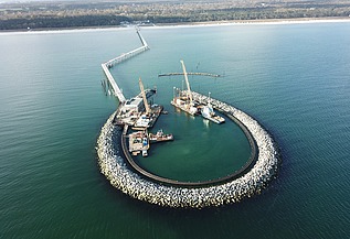 Close-up of a large crane on a construction site in the sea, part of an artificial island construction off Prerow.
