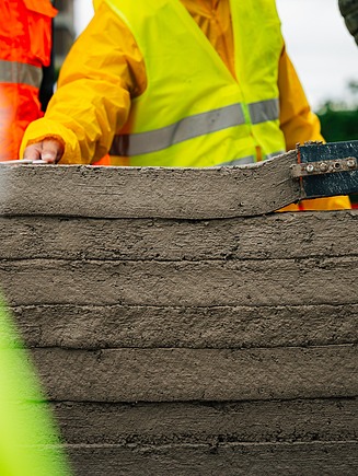 Nahaufnahme eines Druckkopfs einer 3D-Betondruckmaschine bei der Erstellung einer Wand
