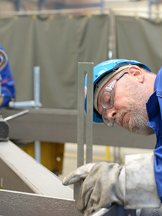 Foto von Mitarbeitern, die eine Stahlkonstruktion montieren