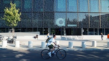 Fahrradfahrer fährt am Axel-Springer-Neubau in Berlin vorbei