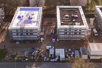 Foto mit zwei Mitarbeiterrn auf einer Baustelle, die sich digitale Pläne auf einem Tablet anschauen                        