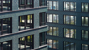 Close-up of the façade of the INK Inspire Neukölln in Berlin consisting of green ceramic tiles