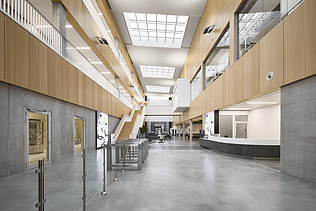 Foto eines großen Innenraumes mit vielen Beton- und Holzoberflächen.