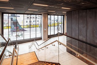 Bild mit Blickrichtung nach draußen, eines Eingangsbereichs mit Treppe eines Bürogebäudes.