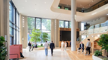 Interior shot of an office building with a large open room containing people.